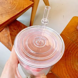Gros plan du couvercle d'un gobelet en plastique à fleurs de cerisier avec paille