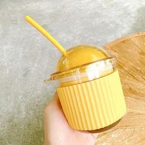 Close-up of a cute yellow egg-shaped glass straw cup with silicone sleeve