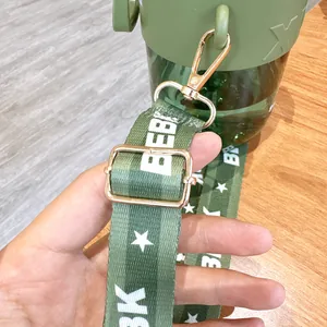 Detail view of the green adjustable strap and golden buckle on children's water cup