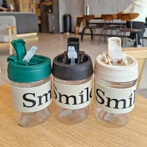 Drei minimalistische Trinkbecher aus Kunststoff mit 'Smile' Hüllen auf Café-Tisch