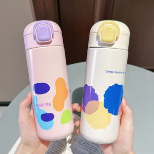 Nahaufnahme von rosa und beigen Isolierflaschen mit bunten, abstrakten Mustern.