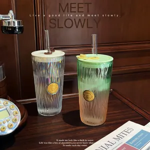 Detailed view of iridescent and gradient glass cups with straws on a vintage desk