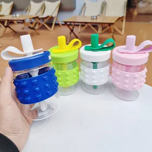 Set of four colorful glass cups with straw lids and heart pattern silicone sleeves.