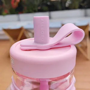 Detail shot of the pink silicone straw cover and lid on a stylish glass water bottle for office