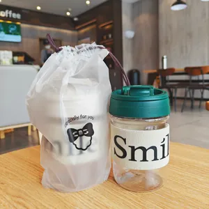 Detailansicht des tragbaren Kunststoff-Kaffeebechers mit Smile-Hülle und passender Geschenktüte
