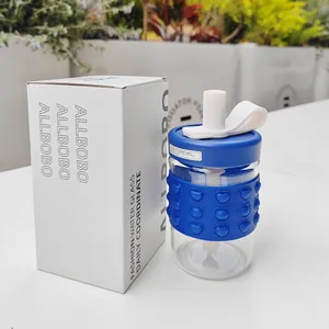 Close-up of glass water bottle with blue heart-patterned silicone sleeve and branded box