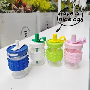 Macro view of four colorful portable glass straw cups with decorative silicone sleeves