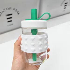 Close-up of minimalist glass straw cup with heart-patterned silicone sleeve