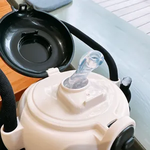 Detailaufnahme einer tragbaren Trinkflasche mit klarem Silikonstrohhalm und schwarzem Klappdeckel