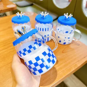 Detail view of Klein blue glass mug with crown lid and blue checkerboard pattern