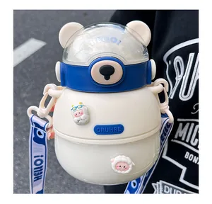Detail of a cute cream and blue bear-shaped water bottle with adjustable 'HELLO!' strap