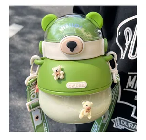 Close-up detail of a cute green bear-themed plastic water bottle with portable strap
