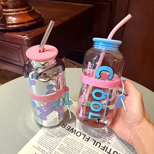 Gros plan de bouteilles d'eau tendance en verre et fini miroir avec des pailles colorées