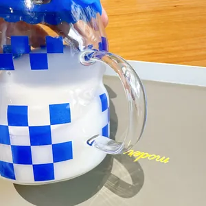 Close-up of glass cup with Klein blue checkerboard pattern and clear handle