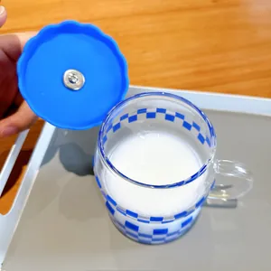 Top-down detail shot of a blue checkered glass mug with its matching lid held open