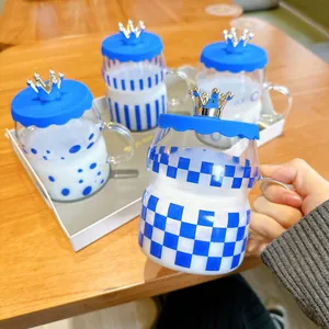 Close-up of a Klein blue checkerboard glass cup with a silver crown lid