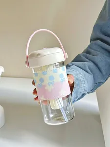 Detailed view of a portable glass water bottle with a pink handle and patterned sleeve
