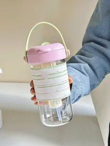 Detail of portable heat-resistant glass tea bottle with pink lid and protective sleeve