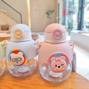 Close-up detail showing two cute children's water bottles with bear characters and straps.