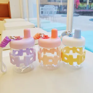 Gros plan de bouteilles d'eau en verre portables avec manchons en silicone colorés