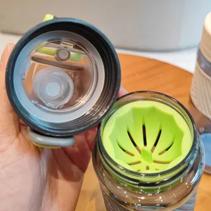 Gros plan du filtre à thé vert citron et du couvercle d'une bouteille de sport en plastique.