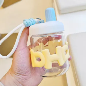 Gros plan d'une bouteille d'eau en verre avec manchon en silicone jaune et couvercle bleu