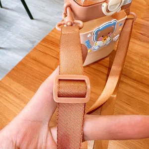 Close-up detail of the adjustable nylon shoulder strap on a cute cartoon square water bottle