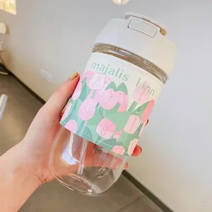 Portable clear glass water bottle with decorative tulip sleeve and straw for daily use