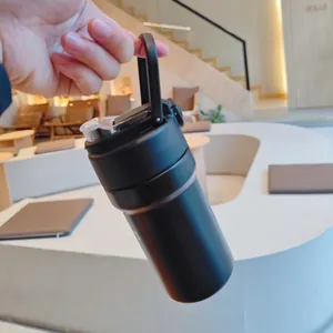 Detail of black insulated stainless steel water bottle with straw and portable handle.