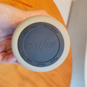 Close-up detail view of the stainless steel coffee cup base with care instructions molded