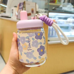 Gros plan d'une bouteille en verre avec étui en cuir floral et dragonne de transport.