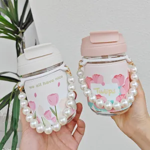 Detailed view of tulip glass water bottles featuring elegant pearl chain handles and sleeves.