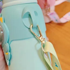 Detalle de botella de agua aislada para niños verde menta con gancho metálico dorado
