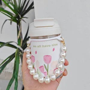 Close-up detail of a tulip pattern glass water bottle featuring an elegant pearl handle chain