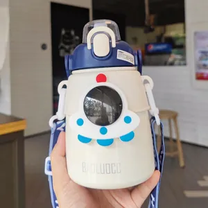 Detail of a cream-colored astronaut themed water bottle with blue lid and safety lock