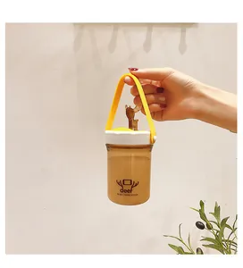 Detail shot of a hand holding a portable plastic water cup with a cute deer lid and yellow strap