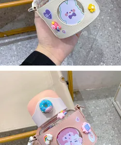 Detailansicht der niedlichen Kinder-Wasserflasche mit Lederhülle und Charms-Dekor