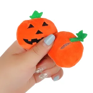Close-up of mini Halloween pumpkin plush brooch showing soft fabric and embroidery