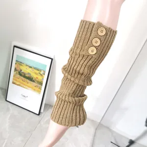 Detailed view of khaki cable-knit leg warmers featuring three decorative wooden buttons