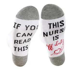Detailed view of white and grey nurse socks featuring humorous text on the soles