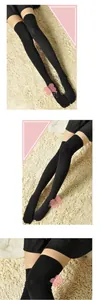 Vue détaillée de chaussettes hautes en coton noir tricoté pour femmes sur un tapis