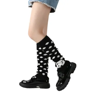 Detail van schattige gebreide puppy beenwarmers met dalmatiërstippen en zwarte schoenen