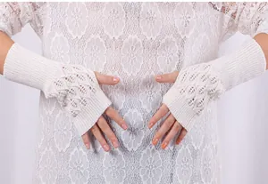 Detailed macro view of women's white hollow-out knitted fingerless long gloves texture