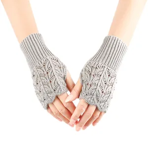Detailed view of grey knitted fingerless gloves with heart-shaped hollow-out patterns
