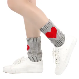 Gezellige grijze gebreide beenwarmers met een levendig rood hartpatroon detail