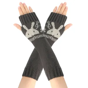 Detail van donkergrijs gebreide armwarmers met een schattig wit konijnenpatroon en duimgaten