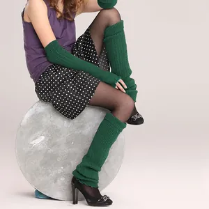 Detailed view of dark green cable-knit leg warmers and matching arm sleeve warmers.