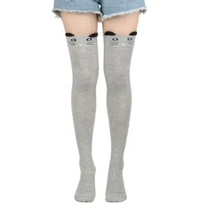 Close-up detail of cute grey cat over-the-knee socks with 3D ears and cartoon face design.