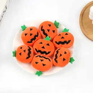 Seven small Halloween jack-o-lantern pumpkin plush doll accessories on a white plate