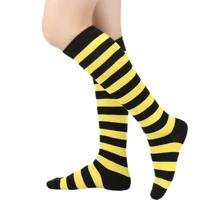 Vue détaillée de chaussettes hautes rayées jaune et noir pour cosplay et sport sur jambe.